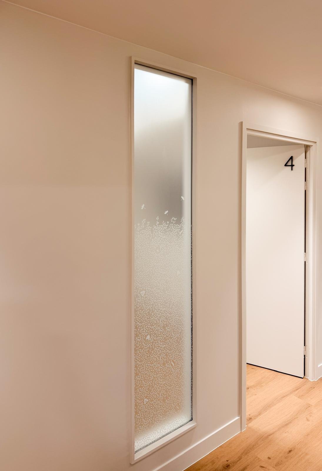 Couloir du centre du sommeil Somnology — verrière dépolie gravée d'un motif de feuillage, Paris 15